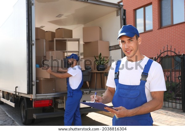 Moving service workers outdoors, unloading boxes and\
checking list