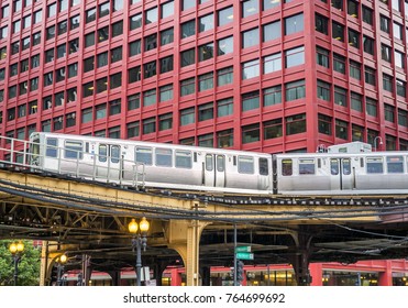 Moving Train on elevated tracks within buildings at the Loop, Glass and Steel bridge between buildings - Chicago City Center - Chicago, Illinois, USA