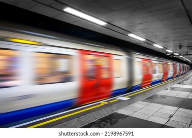 Moving tube train in an undergroud metro station, London