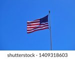 moving of USA flag with sunlight and blue sky background. Flag is represent nationality and patriorism. 