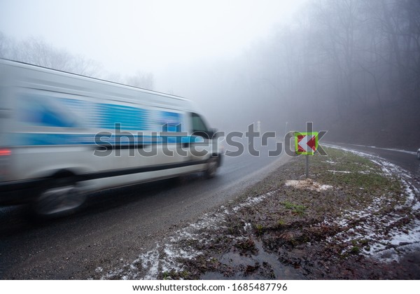 Moving van on highway with\
fog