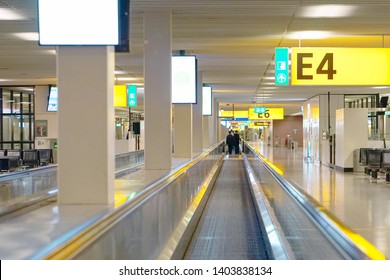 Moving walkway, moving sidewalk, moving pavement, autopedescalator, walkalator, travelator, horizontal escalator, slidewalk, or moveator at an airport.