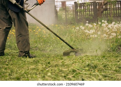 Mowing the grass with a lawn mower. Garden work concept background.