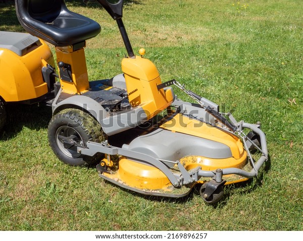 mowing the grass with a\
lawn tractor