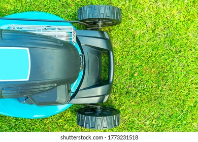 Mowing Lawns. Top View Lawn Mower On Green Grass. Mower Grass Equipment. Mowing Gardener Care Work Tool Close Up View. Sunny Day.