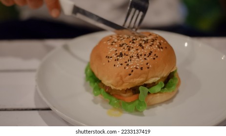 Moza beef burger served at the restaurant. American food style. Delicious gourmet on a wooden table.

 - Shutterstock ID 2233137419
