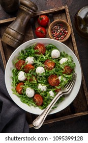 Mozzarella, Tomato And Arugula Salad, Dark Background, Top View