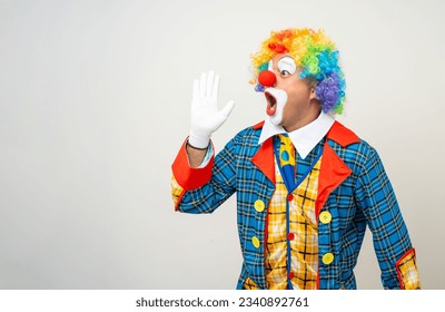 Sr. Clown. El cómico payaso vestido con disfraz colorido y conmocionado vestido con peluca grita alto con el anuncio boca a boca. Feliz expresión asombró a bozo en varias posiciones aisladas.