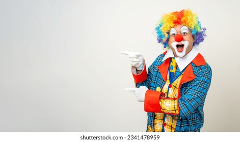 Sr. Clown. Retrato de la cara cómica divertida de Clown man con el dedo indicativo colorido y uniforme para copiar espacio para publicidad de texto. Feliz expresión asombrado bozo masculino en varias posiciones sobre antecedentes aislados.