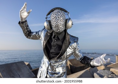Mr disco man with a shiny mirror effect face wearing headphones