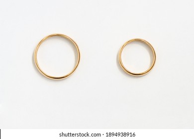 Mr and Mrs bands. Gold rings top view over white paper. For design or drawing.