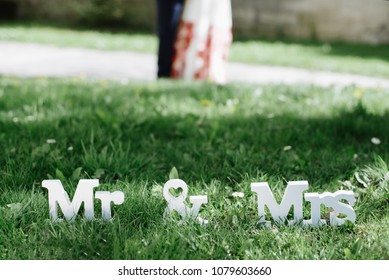 Mr And Mrs White Wedding Letters On Green Grass And Grooms On Background. Wedding Decor. Wedding Details