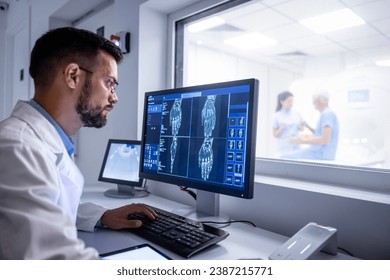MRI diagnostic center control room and neurologist examining patient X-ray images on large display. - Powered by Shutterstock