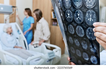 MRI of head of elderly woman in hands of doctor standing in medical ward near senior patient with relative and nurse. Recovery after a stroke - Powered by Shutterstock