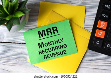 MRR (Monthly Recurring Revenue) - Words On Green Paper On The Background Of A Calculator, And A Cactus. Business Concept