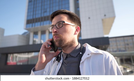 MS Doctor In White Coat Talking On Mobile Phone Front Of Clinic. Man Medic Outside Speaking On Cell Phone. Medicine Healthcare Professional Theme. Physician Discussing With Patient During Phone Talk.