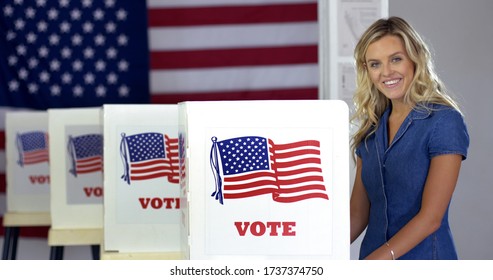 MS Young Blonde Woman Casting Vote At Booths, Looks Up And Smiles In Polling Station With US Flag.