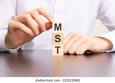 mst, marketing solutions and technologies text on cube blocks in businessman hands, white background
