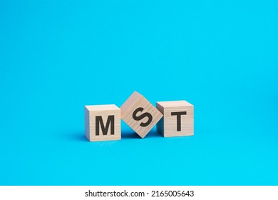 mst text on wooden blocks, business concept, blue background