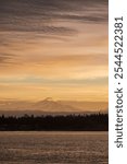 Mt. Baker during a colorful and dramatic sunrise looking across Hale Passage in the Salish Sea area of western Washington state. Seen from Lummi Islands east side during the minutes before sunrise.