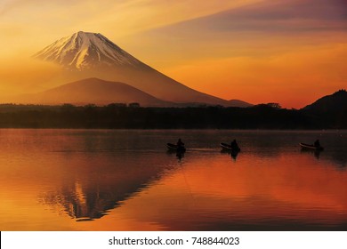 Mt. Fuji or Fujisan with Silhouette three fishing people on boats and mist at Shoji lake with twilight sky at sunrise in Yamanashi, Japan. Landscape with beautiful skyline reflection on the water. - Powered by Shutterstock