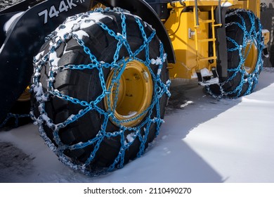 Mt Hood. OR, USA - Nov 16, 2021: Closeup Of The Chained Tires Of A John Deere 744K-II Wheel Loader Working As A Heavy-duty Off-road Snow Plow Tractor In A Ski Area On Mt Hood, Oregon.