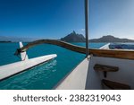 Mt. Otemanu on the island of Bora Bora in Tahiti as seen from a private outrigger heading for a sunset cruise. Vast and pristine turquoise lagoon. Clear blue sky frames a spectacular mountain-scape.