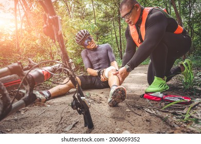 MTB mountain bike accident and first aid : Biker crash crashes, injuring knee and leg, First aid to help mountain biker in accident. Mountain bike athlete first aid team injured during race accident.