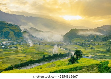 Mu Can Chai, harvesting rice terrace fields landscape with smoke on horizon near Sapa, Northern Vietnam.