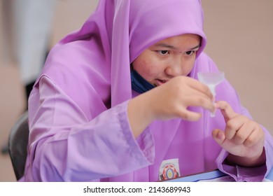 Muadzam Shah, Malaysia - April 7th, 2022 : Lateral-Flow-Test Covid Rapid Home-use Test Kit For Saliva - Step 2 - Spit With Mouth Through Funnel In Plastic Tube To Collect Sample.