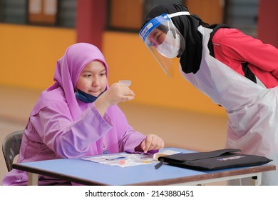 Muadzam Shah, Malaysia - April 7th, 2022 : Lateral-Flow-Test Covid Rapid Home-use Test Kit For Saliva - Step 2 - Spit With Mouth Through Funnel In Plastic Tube To Collect Sample.