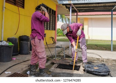 Muadzam Shah, Malaysia - January 3rd, 2019 : The Worker Clears The Clogged Sewer Drain Using Drain Clog Remover To Remove The Dirt Attached To The Channel.