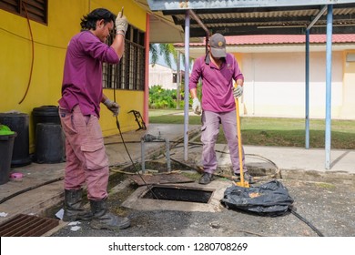 Muadzam Shah, Malaysia - January 3rd, 2019 : The Worker Clears The Clogged Sewer Drain Using Drain Clog Remover  To Remove The Dirt Attached To The Channel