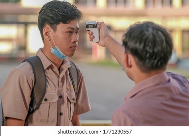 Muadzam Shah, Malaysia - July 7th, 2020 : Teacher Using Thermometer Temperature Screening Student For Fever Against The Spread Of COVID-19 While Student Coming Back To School, Education Concept.