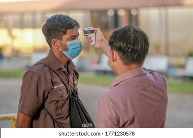 Muadzam Shah, Malaysia - July 7th, 2020 : Teacher Using Thermometer Temperature Screening Student For Fever Against The Spread Of COVID-19 While Student Coming Back To School, Education Concept.