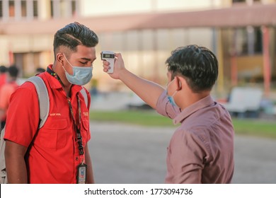 Muadzam Shah, Malaysia - July 7th, 2020 : Teacher Using Thermometer Temperature Screening Student For Fever Against The Spread Of COVID-19 While Student Coming Back To School, Education Concept.