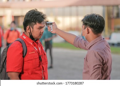 Muadzam Shah, Malaysia - July 7th, 2020 : Teacher Using Thermometer Temperature Screening Student For Fever Against The Spread Of COVID-19 While Student Coming Back To School, Education Concept.