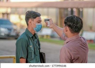 Muadzam Shah, Malaysia - July 7th, 2020 : Teacher Using Thermometer Temperature Screening Student For Fever Against The Spread Of COVID-19 While Student Coming Back To School, Education Concept.