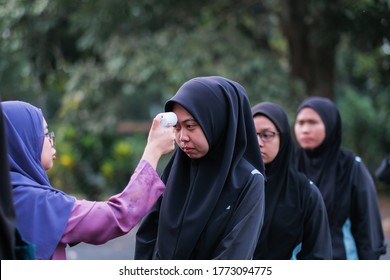 Muadzam Shah, Malaysia- July 9th, 2020:  Teacher Using Thermometer Temperature Screening Student For Fever Against The Spread Of COVID-19 While Student Coming Back To School, Education Concept.