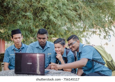 Muadzam Shah, Malaysia - November 15th , 2017 : Happy Young College Students  Sitting Together At Table With  Laptop. Group Of Multiracial People Doing Group Study In College.