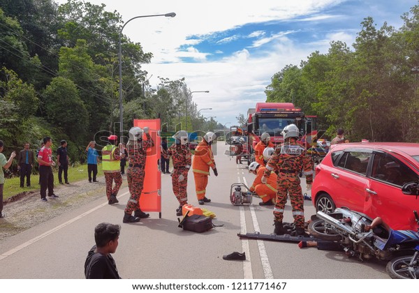 Muadzam
Shah, Malaysia - October 18th, 2018 : Firefighter rescuing wounded
young man in accident between car, bike and bus  in  Inter Agency
Disaster Training Program 2018 at Muadzam
Shah.
