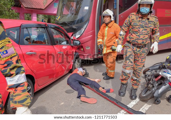 Muadzam\
Shah, Malaysia - October 18th, 2018 : Firefighter rescuing wounded\
young man in accident between car, bike and bus  in  Inter Agency\
Disaster Training Program 2018 at Muadzam\
Shah.