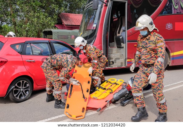 Muadzam Shah, Malaysia - October 18th, 2018 :\
Firefighter and army  rescuing wounded young man in accident\
between car, bike and bus  in  Inter Agency Disaster Training\
Program 2018 at Muadzam\
Shah.