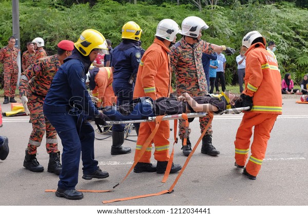 Muadzam Shah, Malaysia - October 18th, 2018 :\
Firefighter and army  rescuing wounded young man in accident\
between car, bike and bus  in  Inter Agency Disaster Training\
Program 2018 at Muadzam\
Shah.