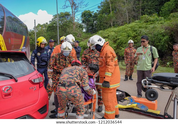 Muadzam Shah, Malaysia - October 18th, 2018 :\
Firefighter  and air force rescuing wounded young man in accident\
between car, bike and bus in Inter Agency Disaster Training Program\
2018 at Muadzam Shah