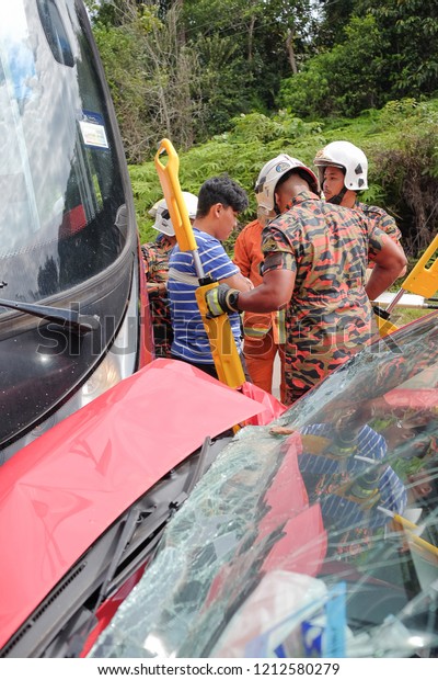 Muadzam\
Shah, Malaysia - October 18th, 2018 : Firefighter rescuing wounded\
young man in accident between car, bike and bus  in  Inter Agency\
Disaster Training Program 2018 at Muadzam\
Shah.