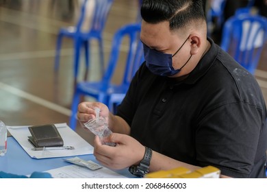 Muadzam Shah, Malaysia - October 31 2021 : Lateral-Flow-Test Covid Rapid Home-use Test Kit For Saliva - Step 2 - Spit With Mouth Through Funnel In Plastic Tube To Collect Sample.