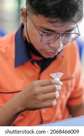 Muadzam Shah, Malaysia - October 31, 2021 : Lateral-Flow-Test Covid Rapid Home-use Test Kit For Saliva - Step 2 - Spit With Mouth Through Funnel In Plastic Tube To Collect Sample.