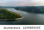 Muak Lek reservoir in Saraburi from aerial bird eye view. Beautiful unseen nature at Muak Lek dam with roadway beside with water and tree hill.
