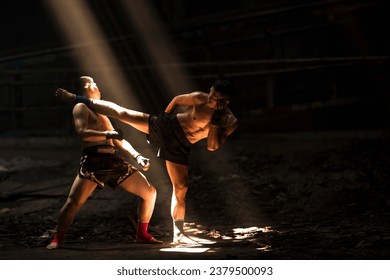 Muay Thai boxers with kick boxing action, thai fighters training boxing in the dark - Powered by Shutterstock